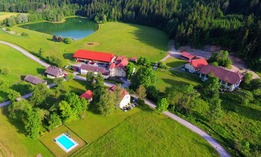 an aerial view of a farm with a house and a lake at Ferien am Talhof in Sankt Urban