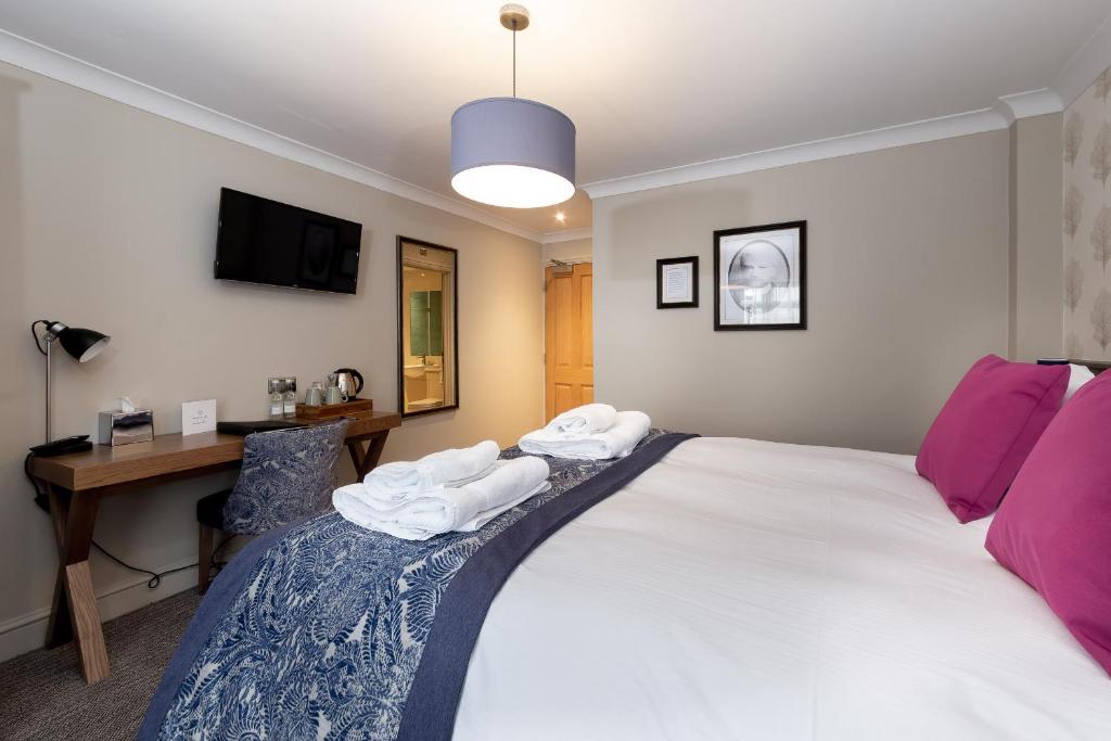 a bedroom with a bed and a desk with a computer at The Eaton Oak in Saint Neots