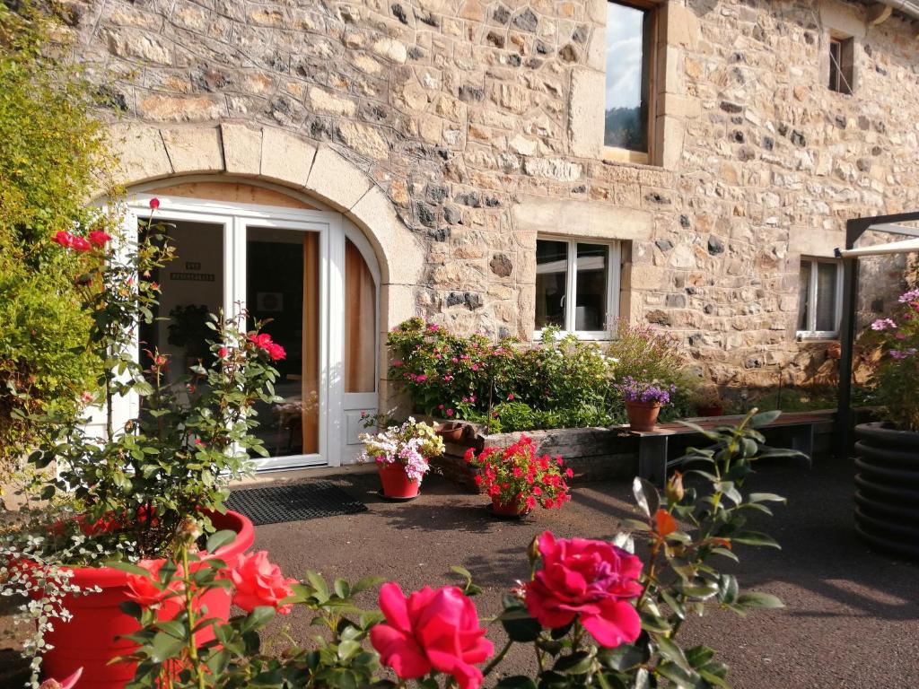 a stone building with flowers in front of a door at Meublé de tourisme La Jaulipière in Joursac