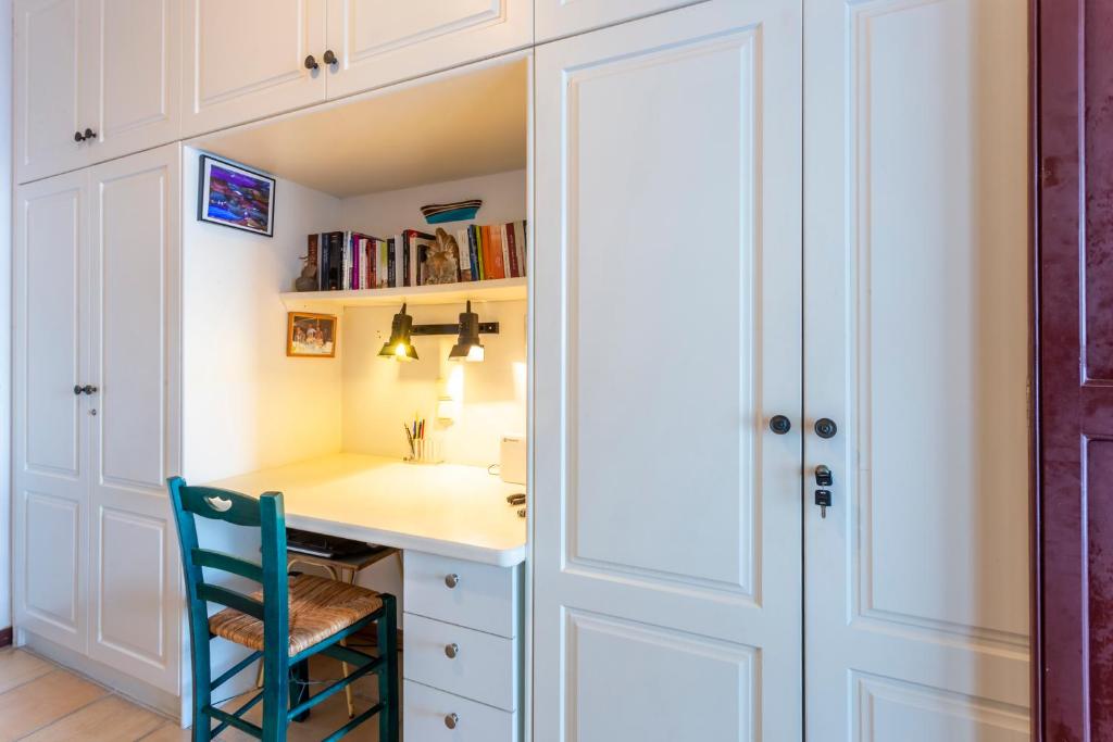 a study room with a desk and a blue chair at Villa Ponente in Spetses