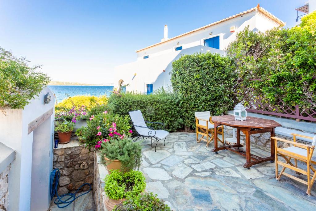 a patio with a table and chairs and the ocean at Villa Ponente in Spetses