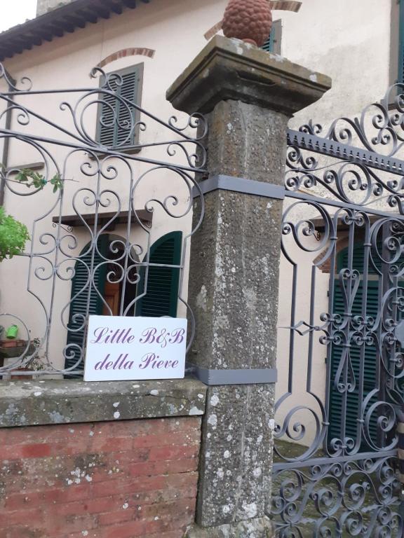een bord aan de zijkant van een gebouw met een hek bij Little B&B Della Pieve in Panzano