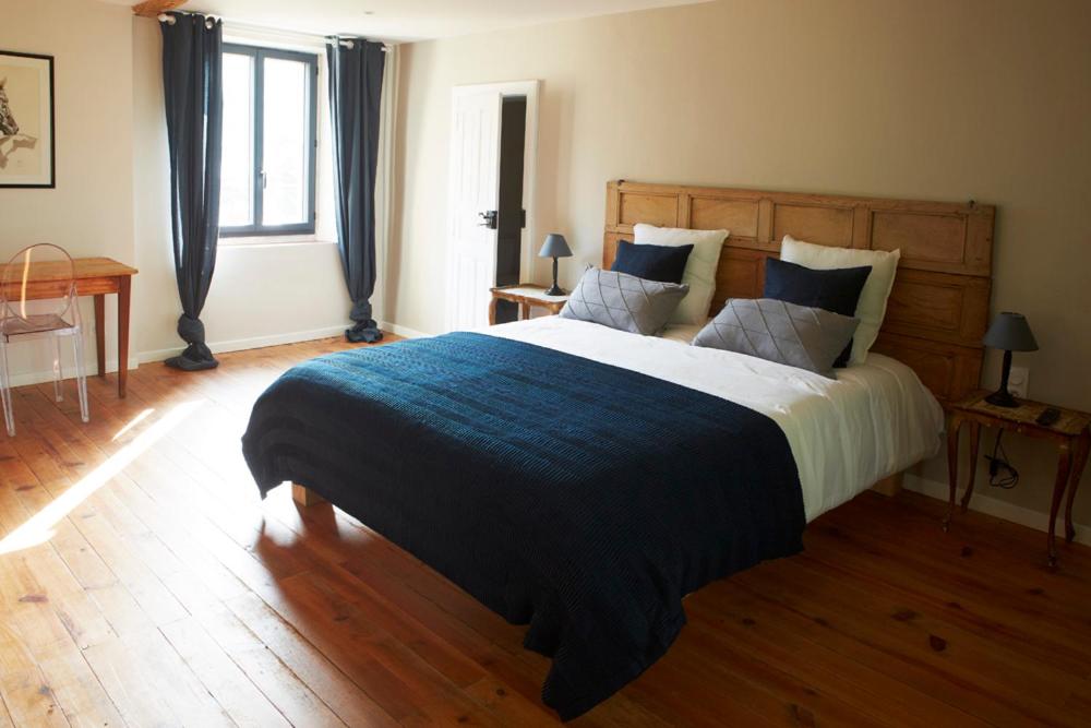 - une chambre avec un grand lit et une couverture bleue dans l'établissement Chambres d'hôtes du Domaine de Bonnery, à Caucalières