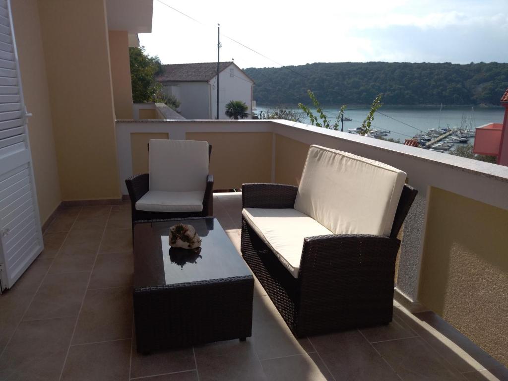 two chairs and a coffee table on a balcony at Apartments Villa Jagoda in Rab