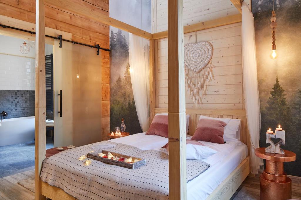 Niedźwiedzia Residence في بورونين: غرفة نوم مع سرير مظلة مع حوض استحمام