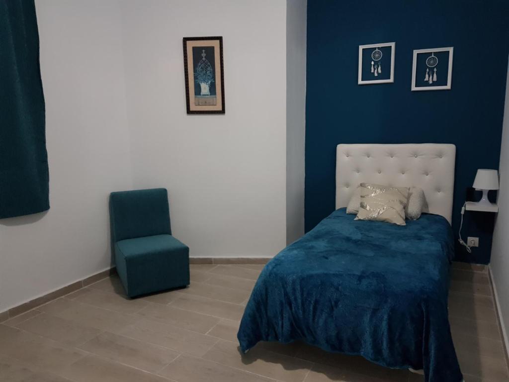 una camera blu con un letto e una sedia blu di La Naval 209, 5ºA - LONDRES - a Las Palmas de Gran Canaria