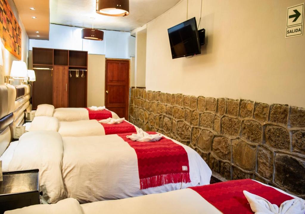 Camera con 4 letti e TV a schermo piatto. di Hotel Royal Qosqo a Cuzco