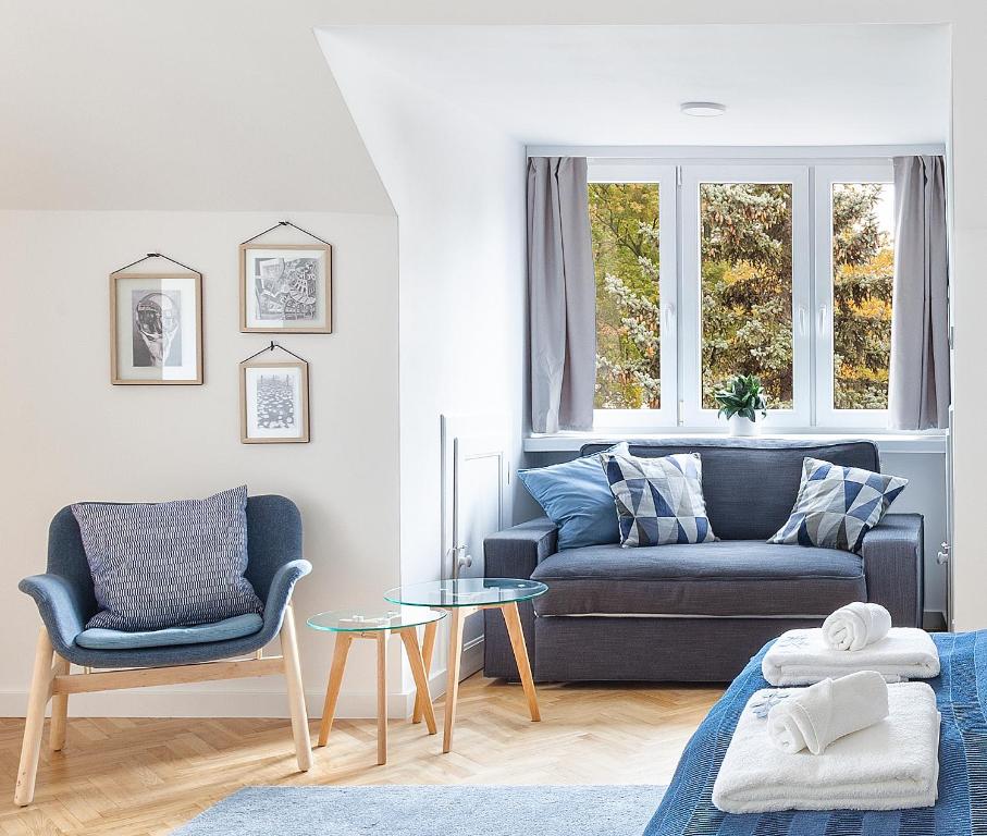 a living room with a blue couch and a table at Opera Apartments in Poznań