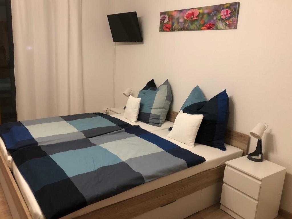 een slaapkamer met een bed met blauwe en witte kussens bij Residenz Peckmann in Gilching