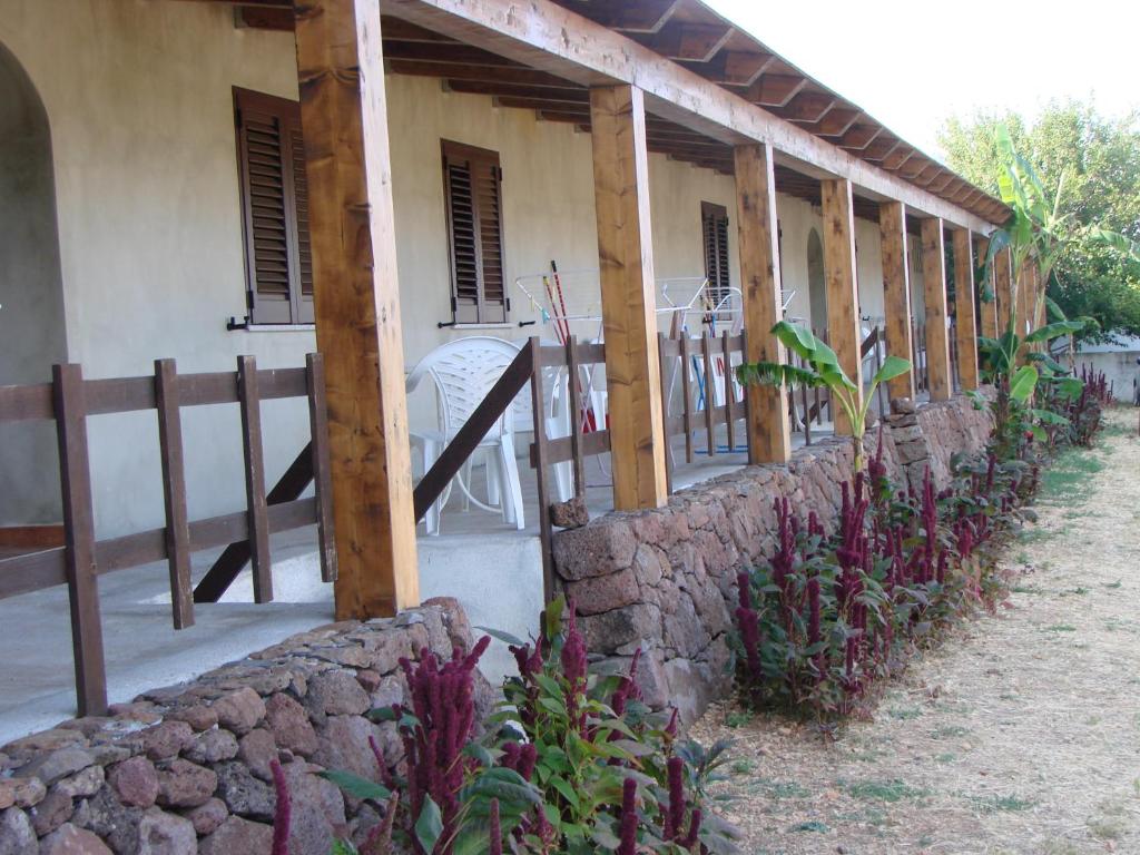 una casa con una recinzione e un muro di pietra di Agriturismo Su Tiresi a Cala Gonone