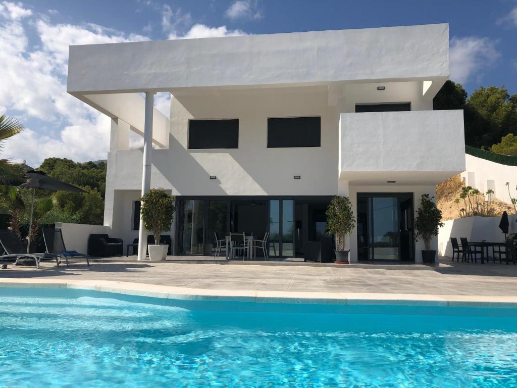 Villa con piscina frente a una casa en Bella Galera, en Altea