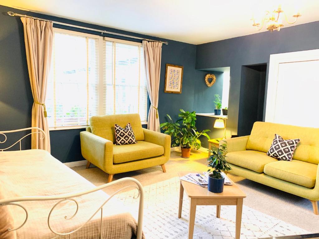 a living room with two yellow chairs and a couch at 'Downtown' @ Terracotta Court in Bradford on Avon