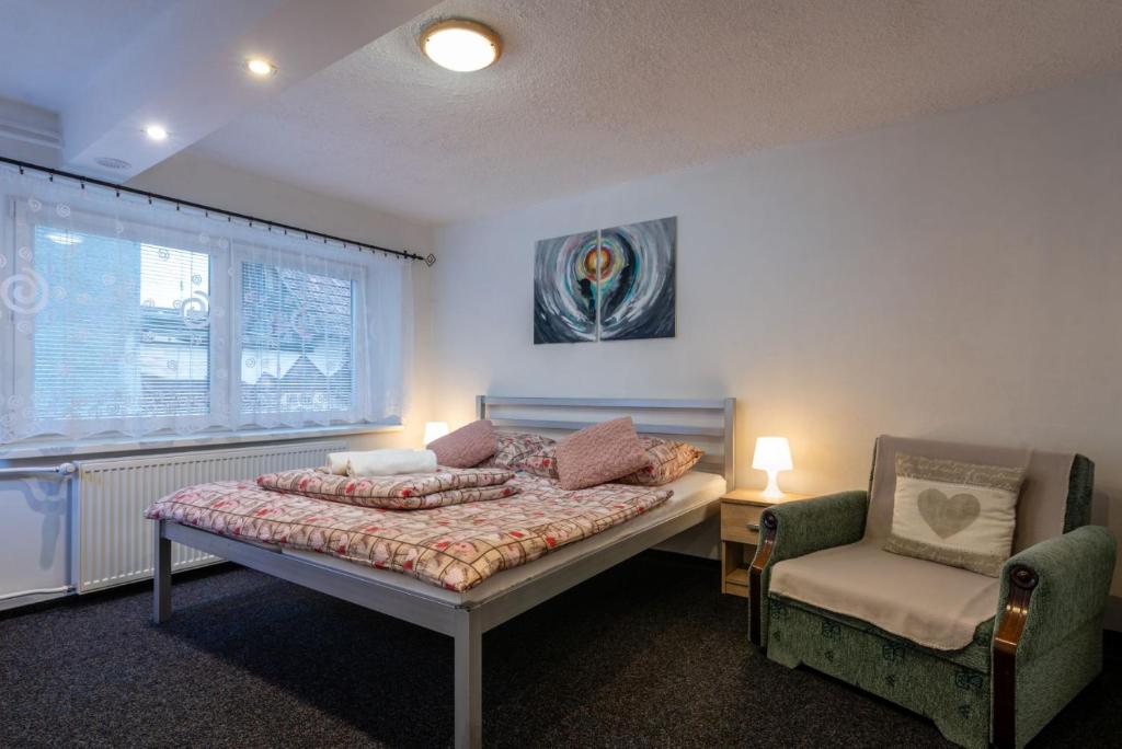 una camera da letto con un letto e una sedia di A&A Apartmany a Liptovský Mikuláš