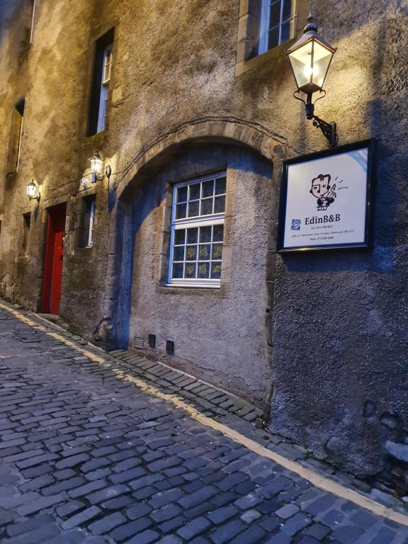 een gebouw met een bord aan de straatkant bij EdinB&B in Edinburgh