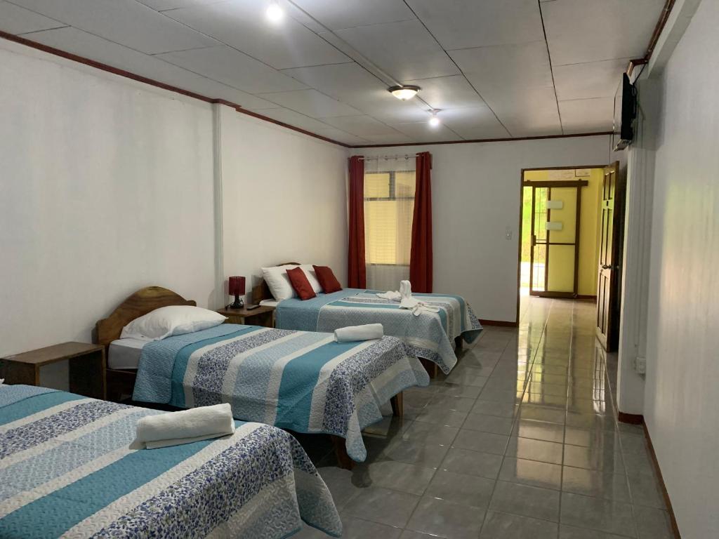 a hotel room with three beds and a hallway at Globi lodge #2 in Monteverde Costa Rica