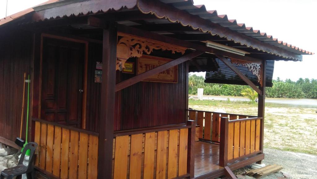 un petit bâtiment en bois avec un toit dans l'établissement Challet Tualang, à Kota Bharu