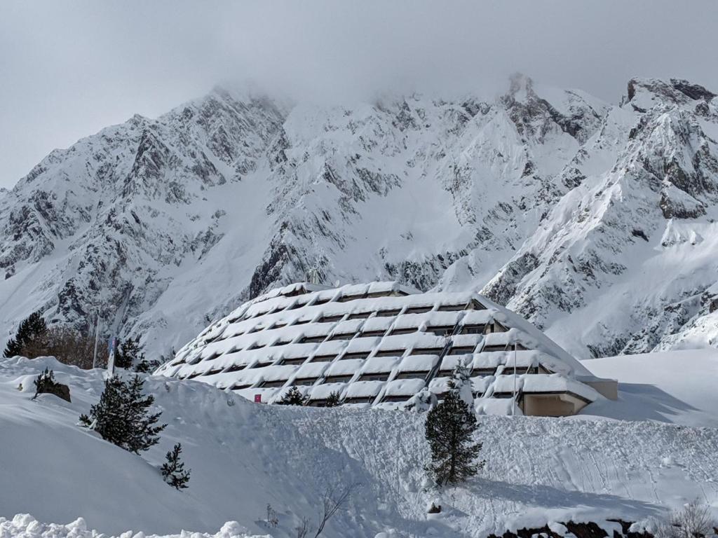 un bâtiment en face d'une montagne enneigée dans l'établissement Appt Résidence Gela, Piau Engaly (studio 6 pers), à Aragnouet