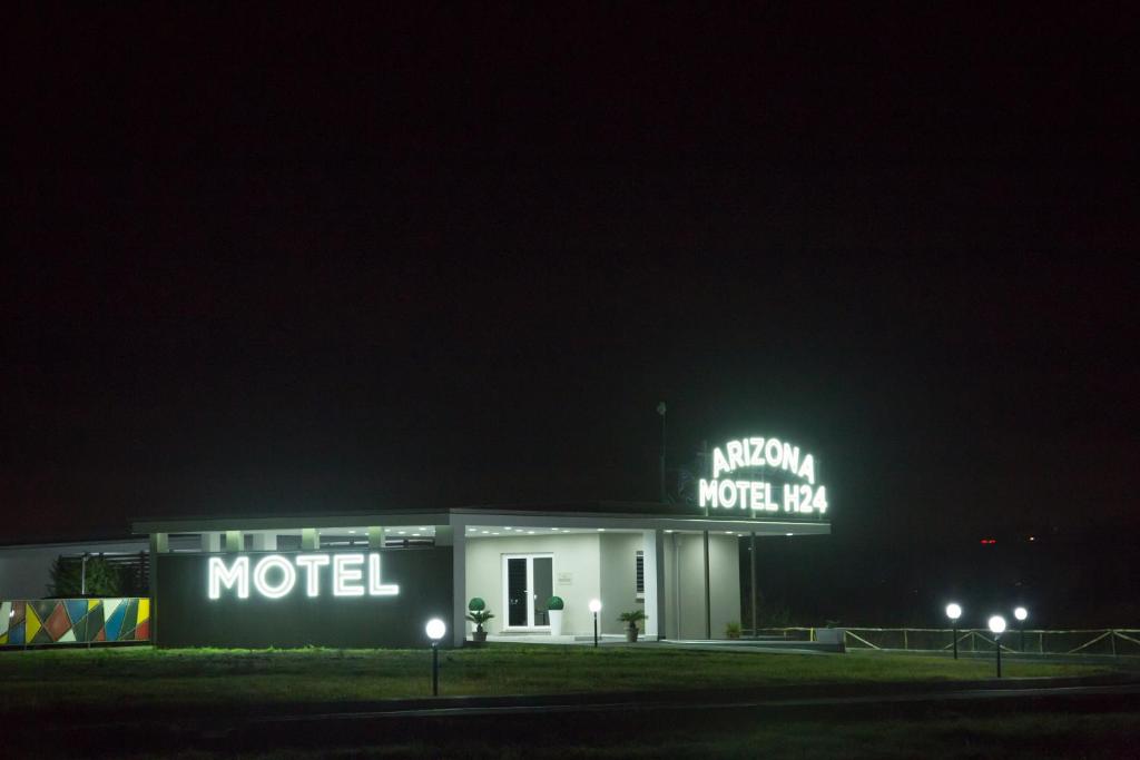 un motel con un cartel de neón por la noche en Arizona Motel, en Castel Volturno