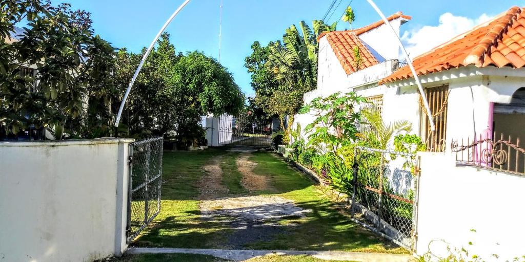 a gate to a yard next to a white house at El Conde de Villa Rosa in Salado