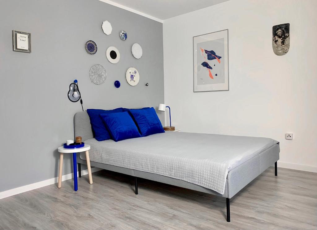 - une chambre avec un lit doté d'oreillers bleus et d'une table dans l'établissement Apartament Leśny - Leśna 30, à Kudowa-Zdrój