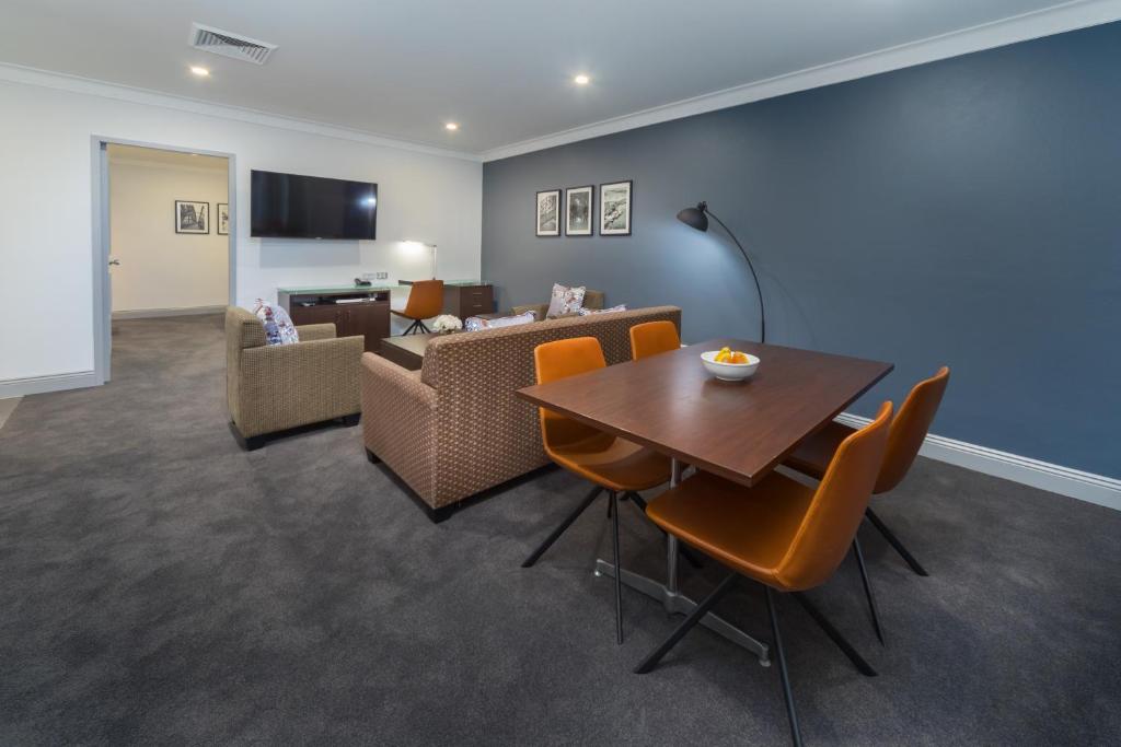 a living room with a table and chairs and a couch at Hyde Park Inn in Sydney