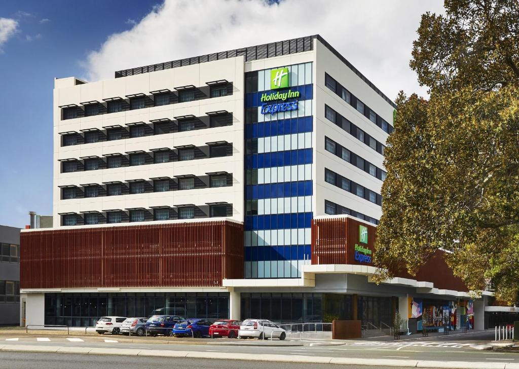 un edificio de oficinas con coches aparcados delante de él en Holiday Inn Express Newcastle, an IHG Hotel, en Newcastle