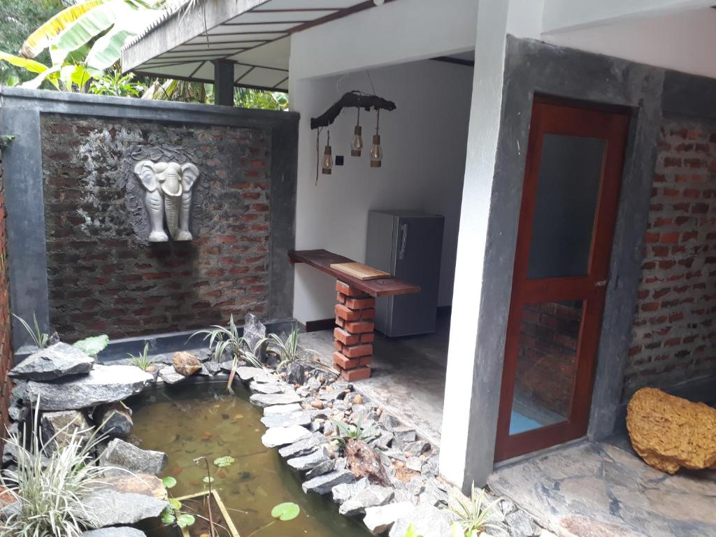 a house with a pond and an elephant on the wall at Selnara Private Luxury Villa and Ayurveda Spa in Bentota