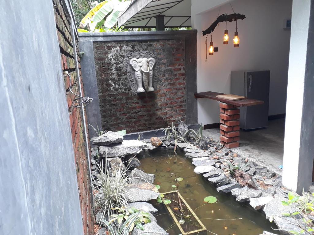 a patio with a pond with an elephant on a brick wall at Selnara Private Luxury Villa and Ayurveda Spa in Bentota