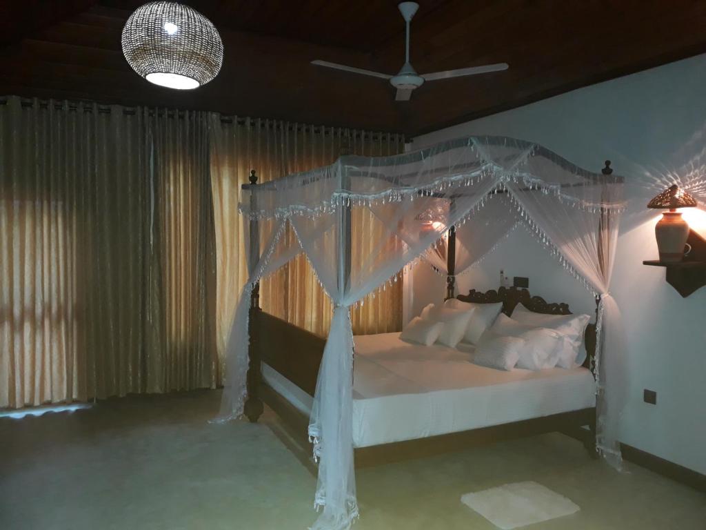 a bedroom with a canopy bed with white pillows at Selnara Private Luxury Villa and Ayurveda Spa in Bentota