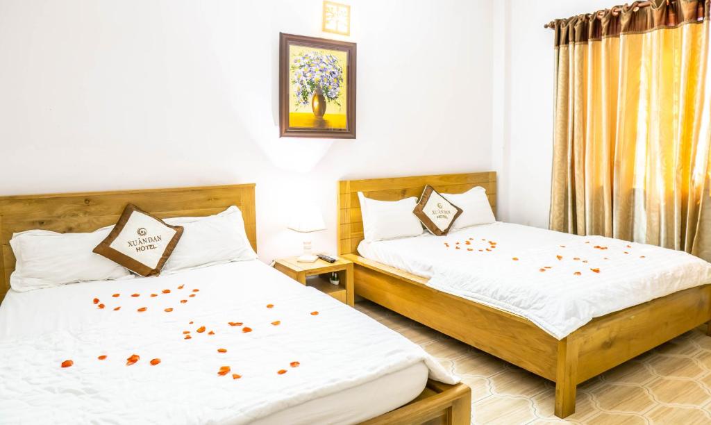 1 dormitorio con 2 camas con flores en las sábanas en Xuan Dan Hotel, en Ho Chi Minh