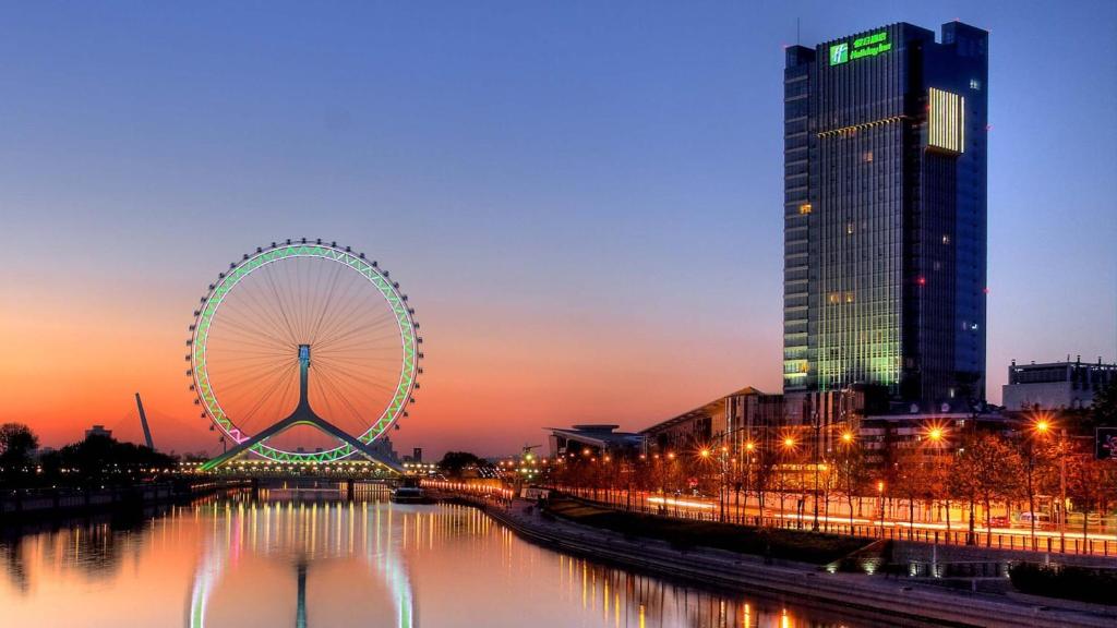 a ferris wheel in a city at sunset at Holiday Inn Tianjin Riverside by IHG in Tianjin