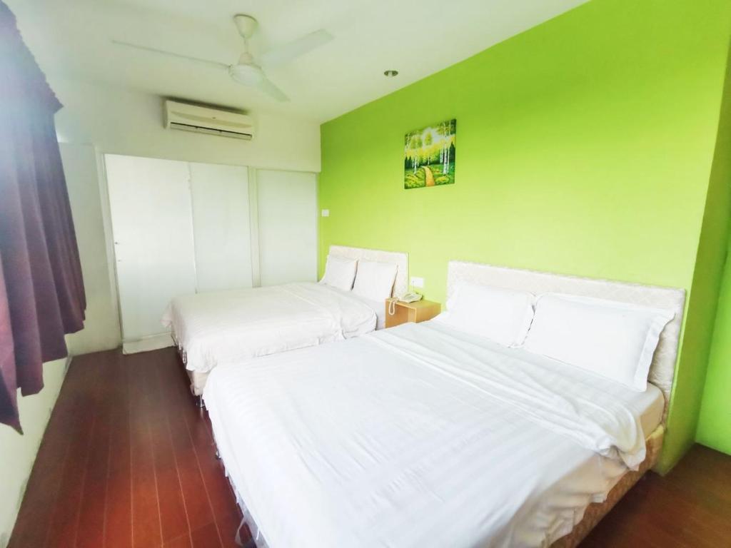 Postel nebo postele na pokoji v ubytování Homestay Kuching Hotel