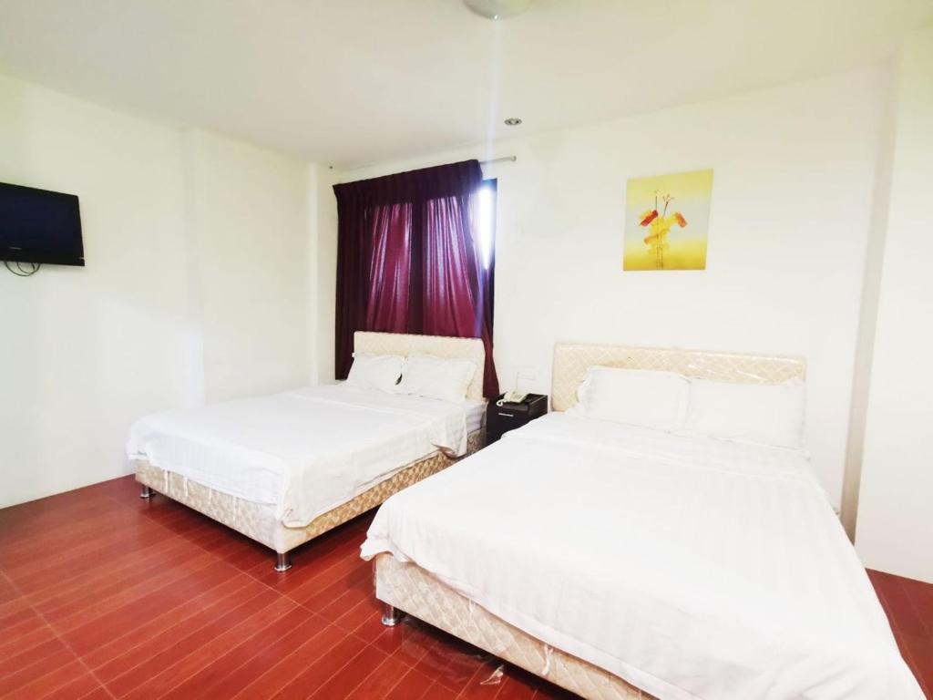 Postel nebo postele na pokoji v ubytování Homestay Kuching Hotel