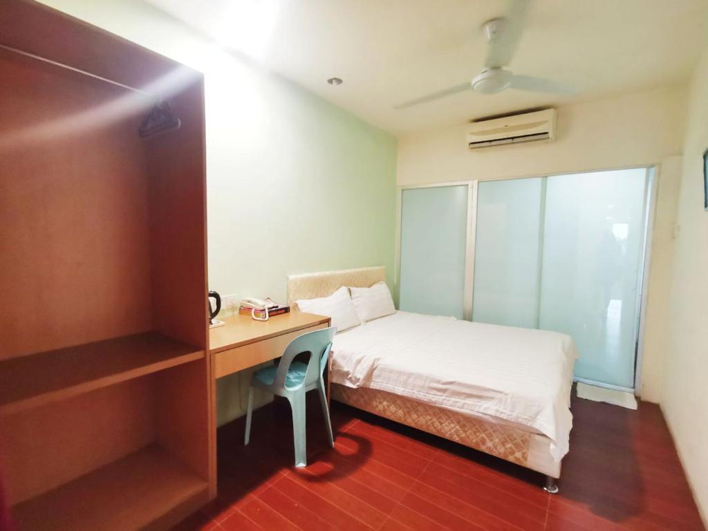 Postel nebo postele na pokoji v ubytování Homestay Kuching Hotel