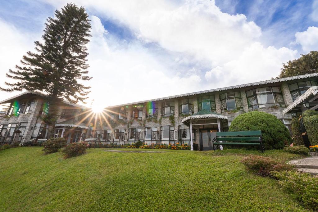 a building with a park bench in front of it at The Elgin Silver Oaks - Heritage Resort & Spa in Kalimpong