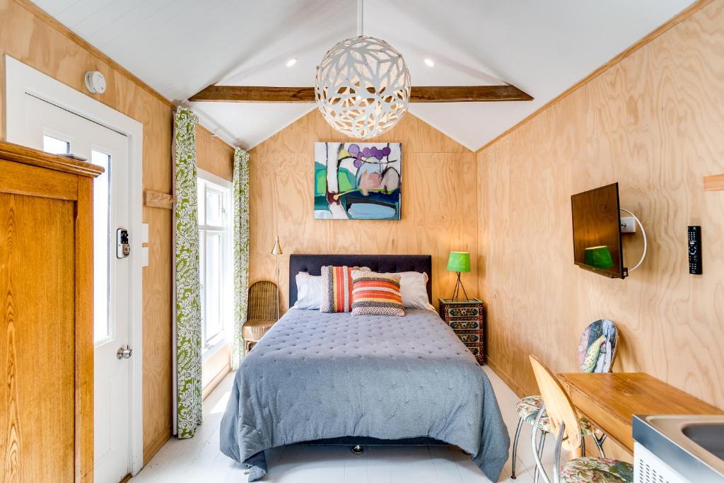 a bedroom with a bed and a chandelier at Ahuriri Studio Cottage in Napier