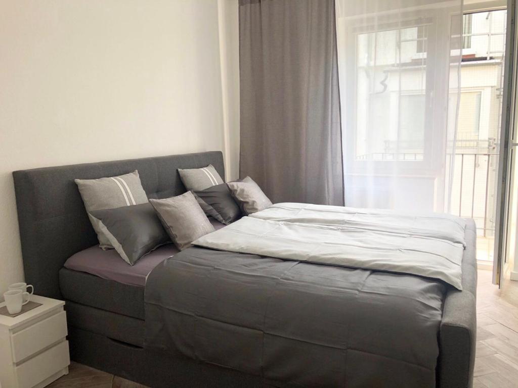 a bed sitting in a room with a window at Apartments City Center Düsseldorf in Düsseldorf