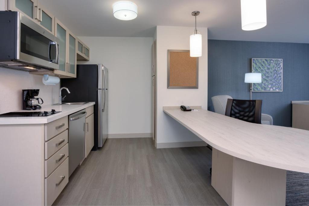 a kitchen with a counter and a refrigerator at Candlewood Suites Miami Intl Airport - 36th St, an IHG Hotel in Miami