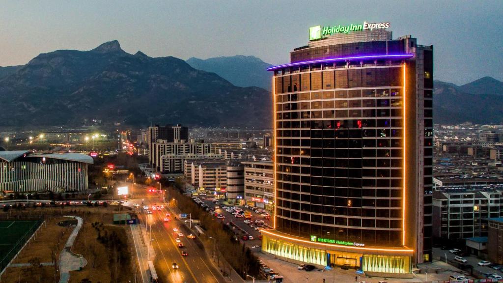 een hoog gebouw met lichten op de top van een stad bij Holiday Inn Express Taian City Center, an IHG Hotel in Tai'an