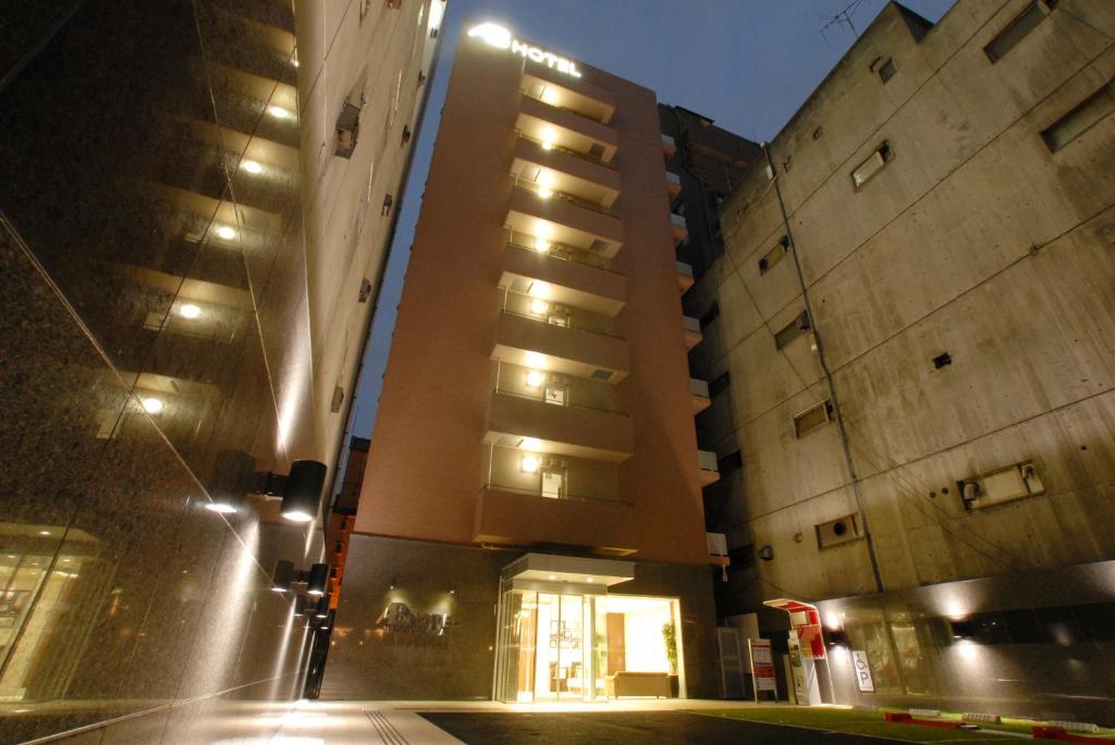 two tall buildings on a city street at night at AB Hotel Nagoya Sakae in Nagoya