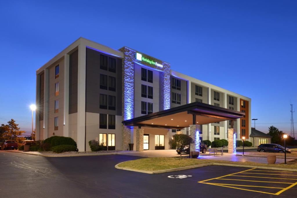 un hotel con un edificio iluminado con aparcamiento en Holiday Inn Express Rochester - University Area, an IHG Hotel, en Rochester