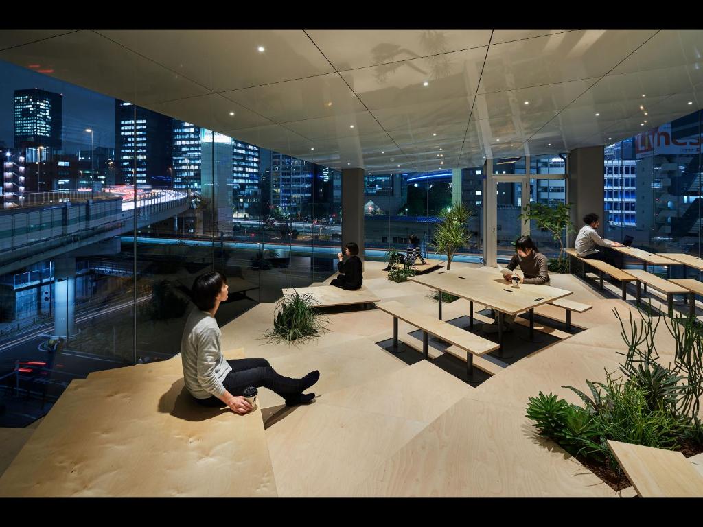 a group of people sitting on top of a building at 9h nine hours Suidobashi in Tokyo