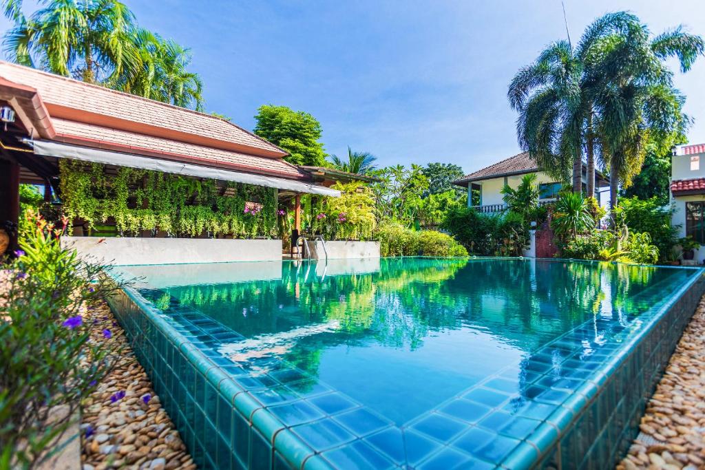 a swimming pool in front of a house at Monaburi Boutique Resort in Rawai Beach