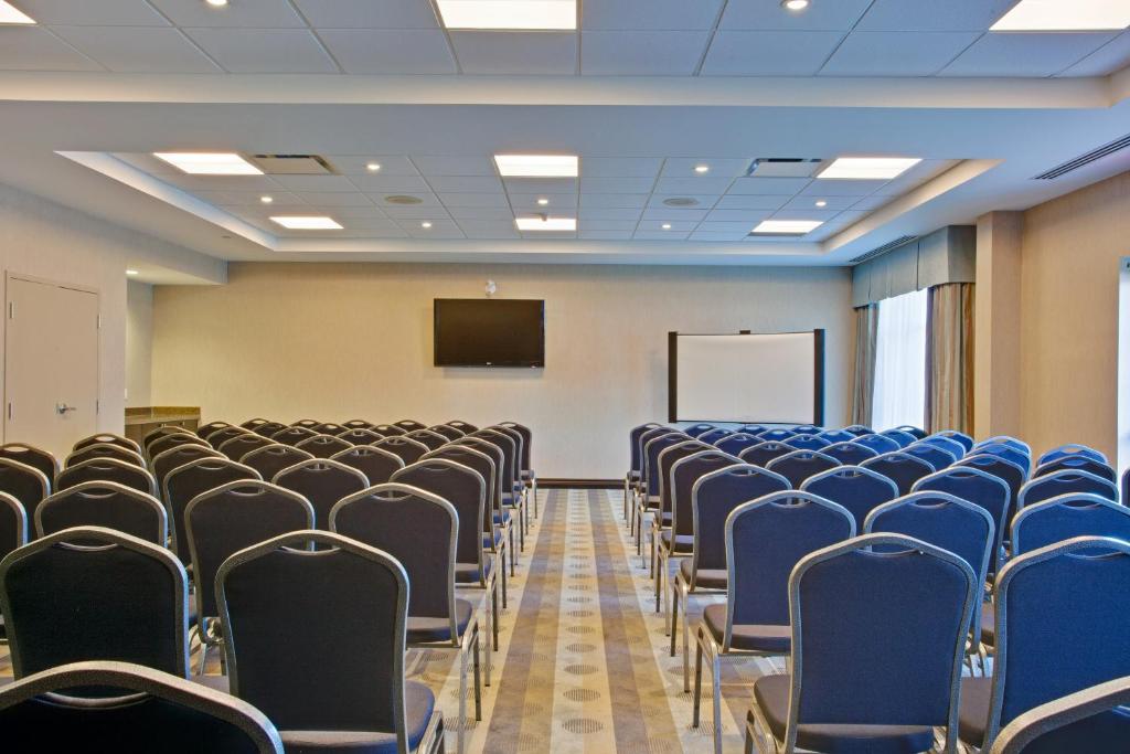 an empty lecture room with chairs and a screen at Holiday Inn Express & Suites Ottawa West - Nepean by IHG in Ottawa
