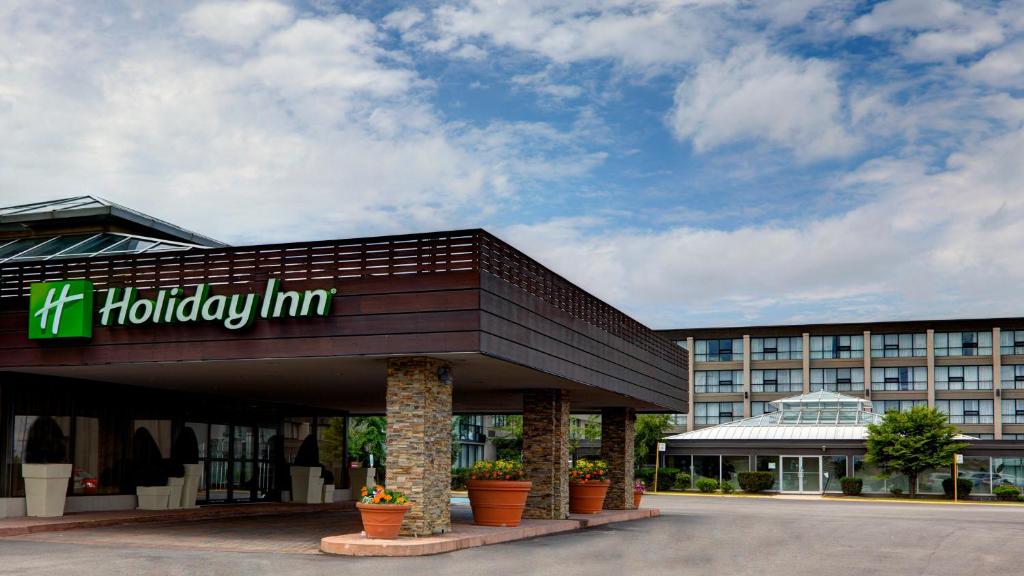 a hotel with a hilton inn sign in front of a building at Holiday Inn Toronto Airport East, an IHG Hotel in Toronto