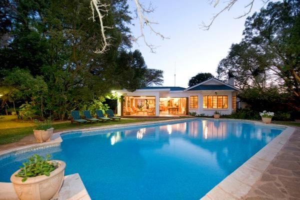 a large blue swimming pool in front of a house at Lupus Den Country House B&B in Sunland