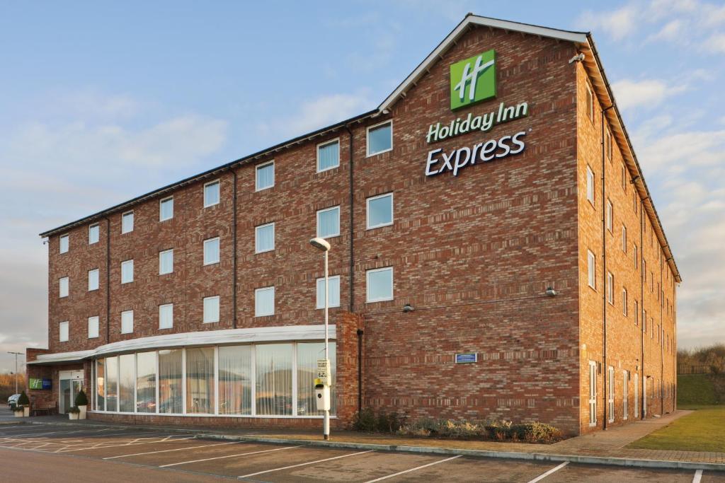 un bâtiment en briques avec l'express de l'auberge fluley écrit sur lui dans l'établissement Holiday Inn Express Nuneaton, an IHG Hotel, à Nuneaton