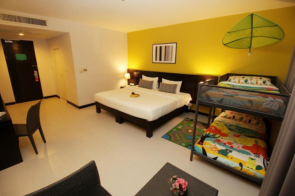 a bedroom with two beds and a bunk bed at Simplitel in Karon Beach