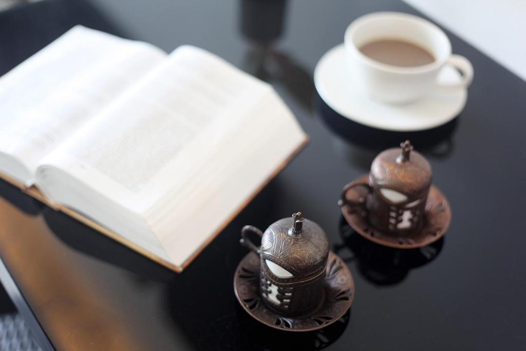 a book and two cups of coffee on a table at Simplitel in Karon Beach