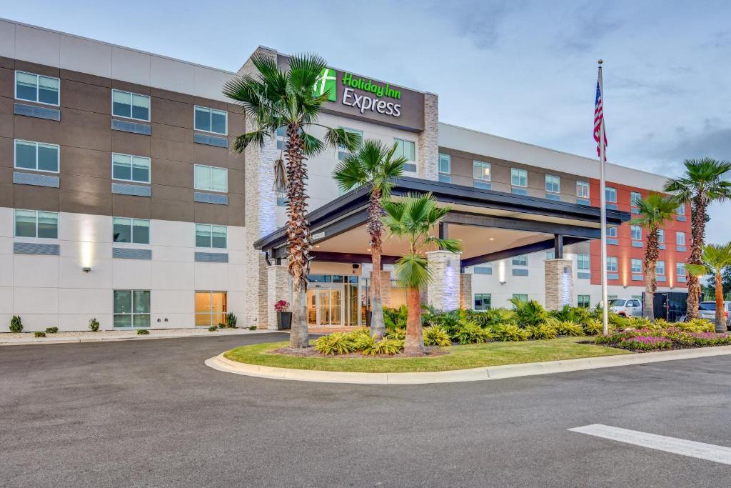 um edifício de escritórios com palmeiras em frente em Holiday Inn Express - Fort Walton Beach Central, an IHG Hotel em Fort Walton Beach